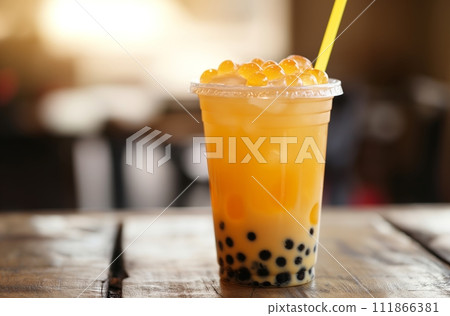AI-generated content. A refreshing mango-flavored bubble tea with translucent popping boba on top, served with a straw in a clear plastic cup 111866381