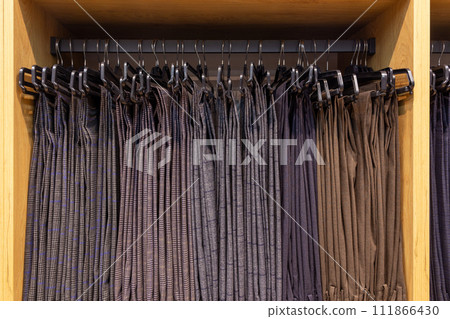 Men's classic trousers on hangers in a boutique. 111866430