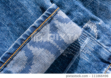Blue jeans with patterns on the cuffs and decorative seams close up Blue jeans with patterns on the cuffs and decorative seams close up 111866496