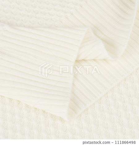 Knitted elastic band on creamy white wool sweater close up 111866498