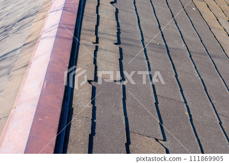 damaged slate roof 111869905