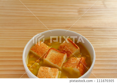 A bowl of grained corn soup and sliced toast A bowl of grained corn soup and sliced toast 111870305