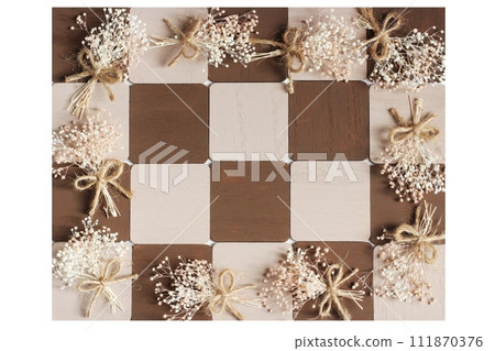 Square brown and beige wood with a bouquet of small gypsophila on the wood arranged in a checkered pattern 111870376