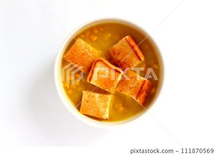 A bowl of grained corn soup and sliced toast 111870569