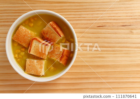 A bowl of grained corn soup and sliced toast A bowl of grained corn soup and sliced toast 111870641