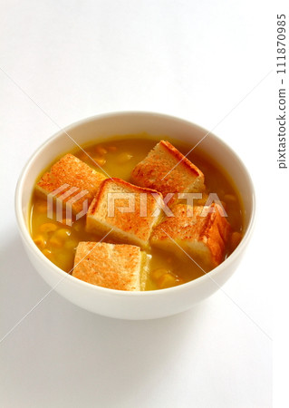 A bowl of grained corn soup and sliced toast A bowl of grained corn soup and sliced toast 111870985