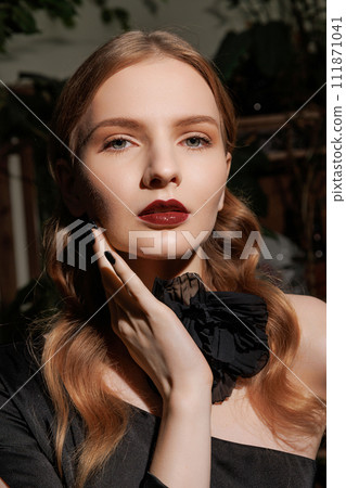 Portraint woman with wavy hair, dark attire. 111871041