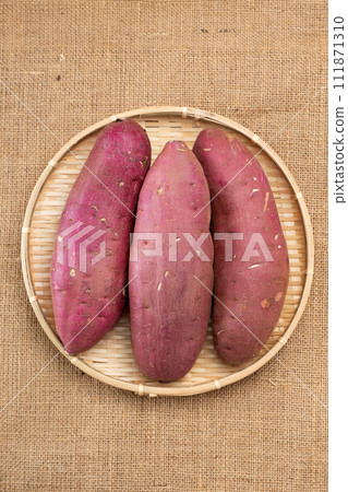 Sweet potatoes on linen background in a colander 111871310