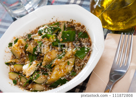 Salad of broken cucumbers with sesame seeds, sugar, red and black pepper, olive oil 111872808