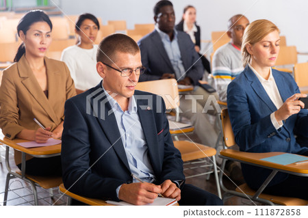 Man listening to speaker on business training in conference hall Man listening to speaker on business training in conference hall 111872858