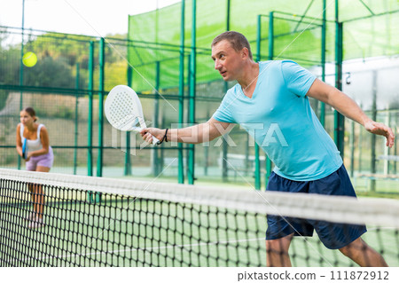Man training to play tennis on padel court outdoor Man training to play tennis on padel court outdoor 111872912