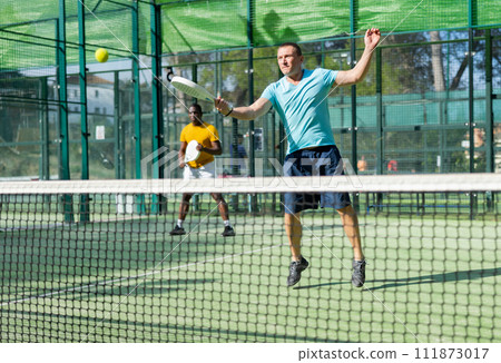 European man padel tennis player trains on the court European man padel tennis player trains on the court 111873017