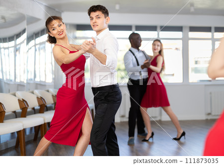 Young guy and adult woman dance tango Young guy and adult woman dance tango 111873035