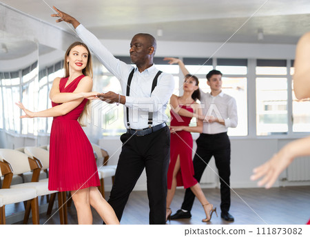 African man and woman dancing waltz in couple during lesson at studio 111873082