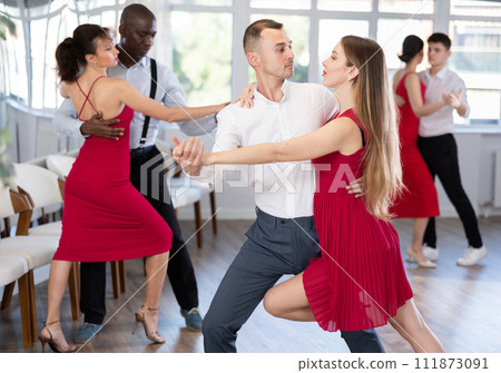 Young man and girl dancing tango in couple during lesson at studio 111873091