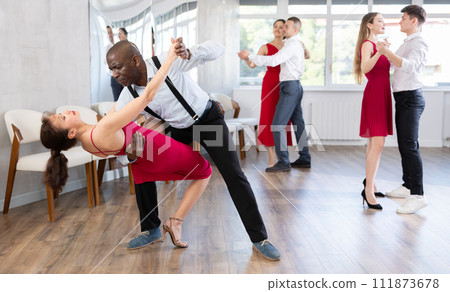 African man and woman dancing tango in couple during lesson at studio African man and woman dancing tango in couple during lesson at studio 111873678