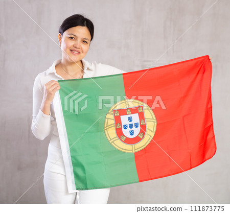 Pretty smiling female football fan holding Portugal flag 111873775