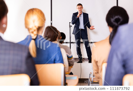 Male coach giving speech at conference hall Male coach giving speech at conference hall 111873792