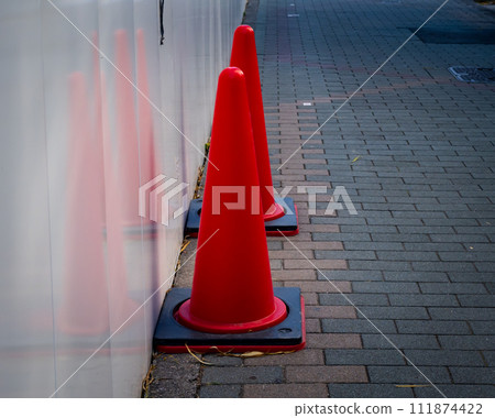 A landscape where red road cones installed at an urban construction site stand out 111874422