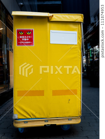 Stickers with illustrations of eyes are pasted on large yellow luggage compartments around town. Stickers with illustrations of eyes are pasted on large yellow luggage compartments around town. 111874953