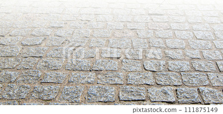 Granite cobblestoned pavement background on sunlight 111875149