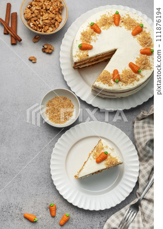 Homemade carrot cake made with walnuts, iced with cream cheese. Sweet dessert. 111876194