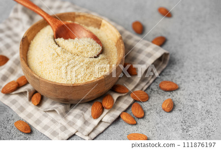 Fresh almond flour in a bowl and almonds Fresh almond flour in a bowl and almonds 111876197