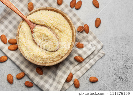 Fresh almond flour in a  bowl and almonds 111876199