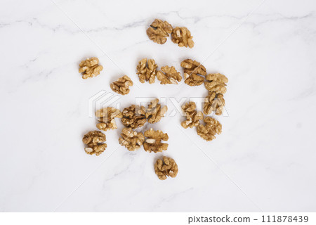 Walnuts are scattered on the marble table 111878439