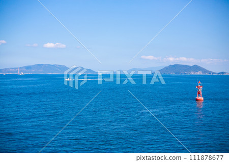 Seto Inland Sea, islands, and red buoys seen from the ferry heading to Naoshima 111878677