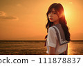 A girl standing in the sea at sunset - A composite image of the sunset in the live-action background and the AI-generated girl 111878837