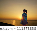 A girl standing on the beach in the sunset - A composite image of the sunset in the live-action background and the AI-generated girl 111878838