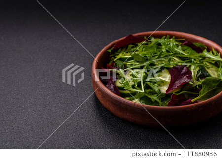 Delicious fresh salad with arugula, spinach, cucumber and cherry tomatoes in a ceramic plate Delicious fresh salad with arugula, spinach, cucumber and cherry tomatoes in a ceramic plate 111880936