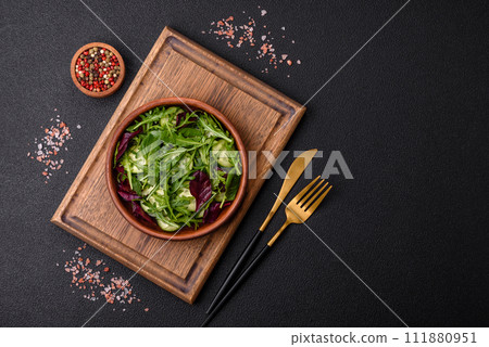 Delicious fresh salad with arugula, spinach, cucumber and cherry tomatoes in a ceramic plate 111880951