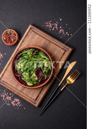 Delicious fresh salad with arugula, spinach, cucumber and cherry tomatoes in a ceramic plate 111880952