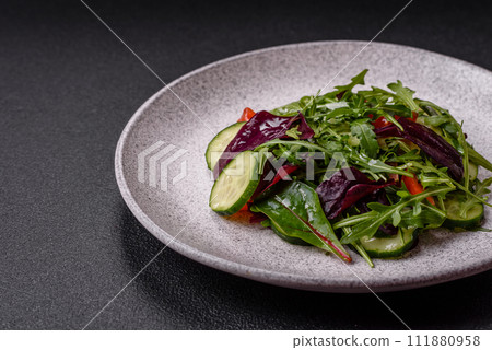 Delicious fresh salad with arugula, spinach, cucumber and cherry tomatoes in a ceramic plate 111880958
