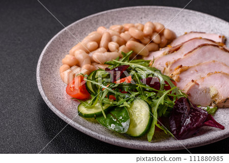 Delicious dietary salad with arugula, cucumber and cherry tomatoes and chicken breast slices 111880985