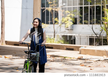 Eco friendly, Happy lifestyle asian beautiful young businesswoman riding bicycle go to office work at city street with bicycle in morning Eco friendly, Happy lifestyle asian beautiful young businesswoman riding bicycle go to office work at city street with bicycle in morning 111881913