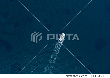 Small fishing boat in the deep blue sea. Overhead view 111883068