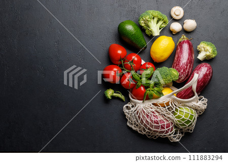 Mesh bag filled with a variety of vegetables 111883294