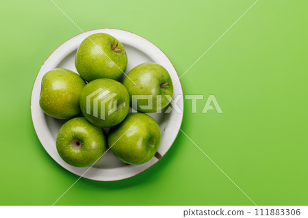 Plate with fresh green apples 111883306