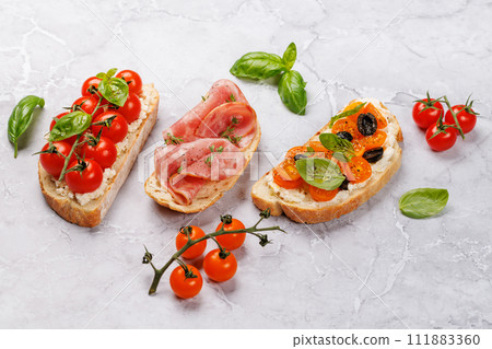 Sandwich set of bruschetta with juicy tomatoes, cheese and prosciutto Sandwich set of bruschetta with juicy tomatoes, cheese and prosciutto 111883360