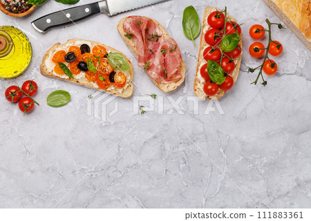 Sandwich set of bruschetta with juicy tomatoes, cheese and prosciutto 111883361