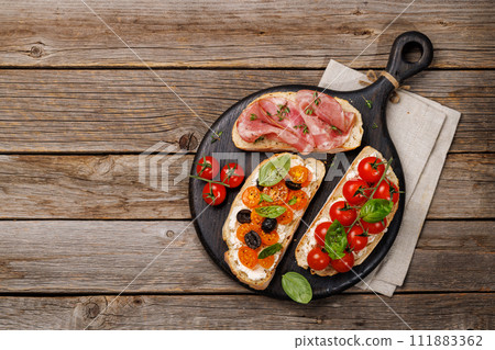 Sandwich set of bruschetta with juicy tomatoes, cheese and prosciutto 111883362