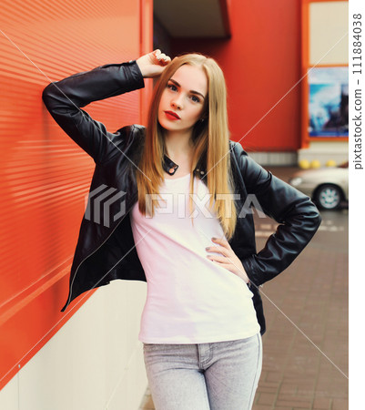 Portrait of beautiful blonde young woman wearing black leather rock style jacket in the city Portrait of beautiful blonde young woman wearing black leather rock style jacket in the city 111884038