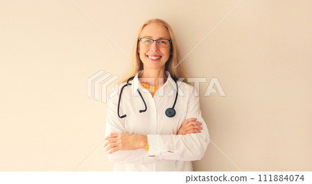 Portrait of happy friendly smiling middle-aged woman doctor with stethoscope and crossed arms 111884074