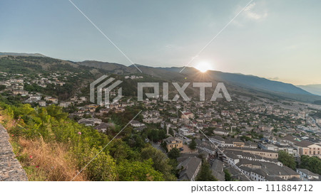 Panorama showing sunset over Gjirokastra city from the viewpoint of the fortress of the Ottoman castle of Gjirokaster timelapse. 111884712