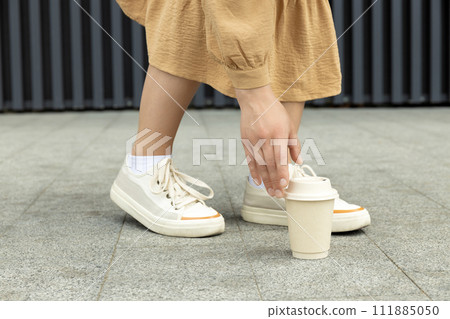 Girl with flowers and coffee, on the street in summer. 111885050