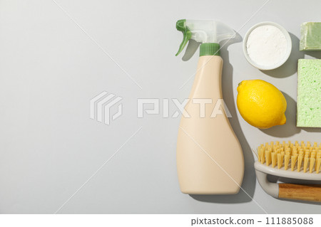 Spray bottle, cleaning tools and natural cleaning products on gray background, space for text 111885088