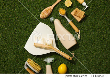 Brushes, scoop, bottle, soap and lemon on green background, top view 111885090
